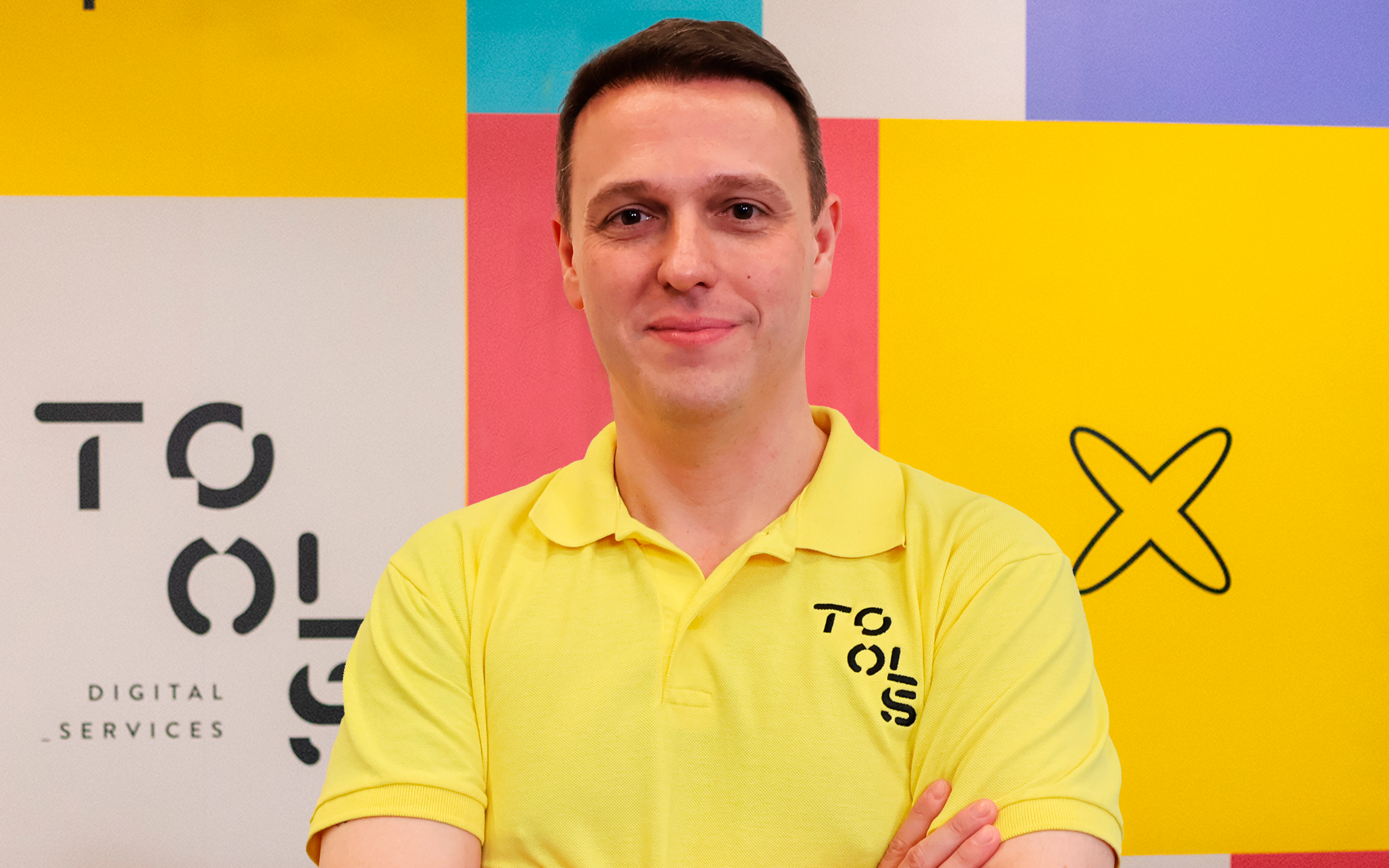 Homem branco com camisa polo amarela TOOLS