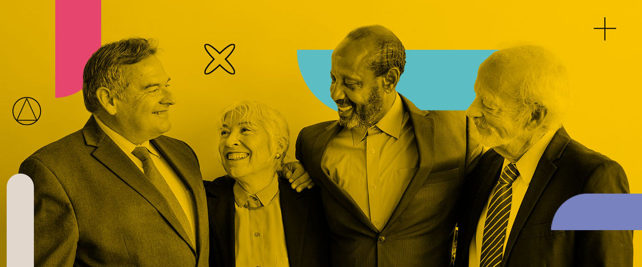 Um grupo de quatro pessoas seniors de diferentes etnias em ambiente corporativo.