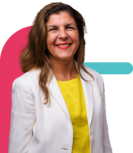 Mulher branca sênior sorrindo, com casaco branco e camiseta amarela.